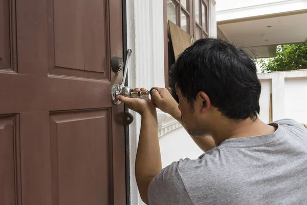 Cerrajero tratar de abrir la puerta con herramientas — Foto de Stock