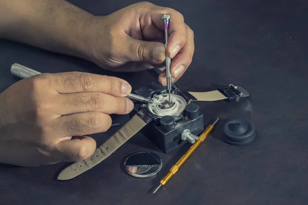 Zegarmistrz spróbować naprawić zegarek na narzędzia i tabeli — Zdjęcie stockowe