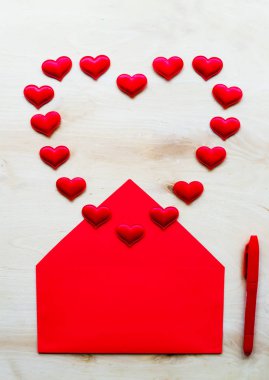 Zarf ve kalem ahşap arka plan üzerinde kırmızı kalp şekli