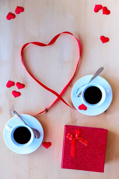 Δυο φλιτζάνια με καφέ, διακοσμημένο με κορδέλα στο ξύλινο τραπέζι. — Φωτογραφία Αρχείου