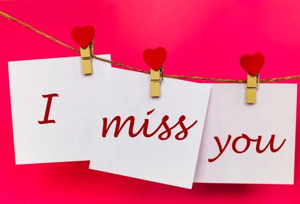 Miss you text on stickers hanging on heart shape pins