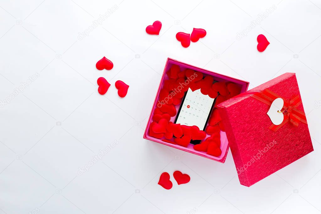 Smartphone with calendar at Valentine's day date in gift box