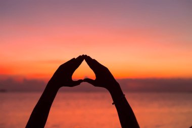 Gün batımı arka plan el ile kalp şekli