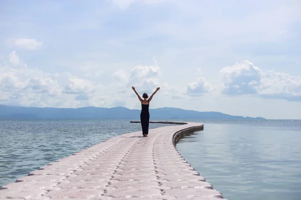 Pier deniz üzerine siyah elbiseli genç kadın