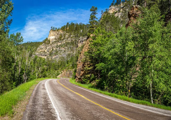 Spearfish Canyon Scenic Byway, 14A karayolunun her iki tarafında da kahverengi, pembe ve gri tonlarda, 360 metre yüksekliğindeki kireçtaşı kanyon duvarlarına sahiptir..