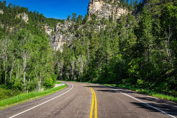 Spearfish Canyon Scenic Byway features thousand-foot-high limestone canyon walls in shades of brown, pink and gray along both sides of Highway 14A as it twists through the 19-mile gorge.