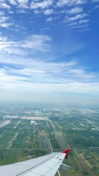 Ala de avião, terra verde e céu azul — Fotografia de Stock