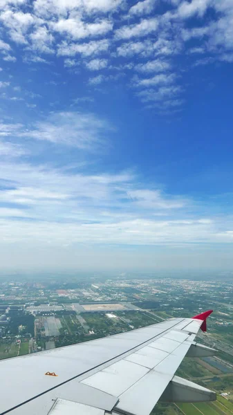Ala de avião, terra verde e céu azul — Fotografia de Stock