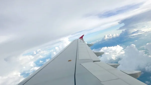 Céu azul fundo nebuloso e asa do avião — Fotografia de Stock