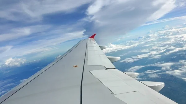 Céu azul fundo nebuloso e asa do avião — Fotografia de Stock