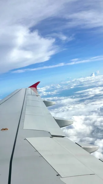 Blue sky cloudscape background and wing of airplane — Stock Photo, Image