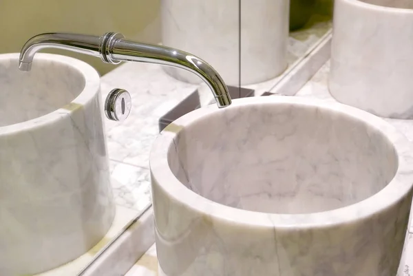 Indoor modern water sink with mirror reflection in restroom