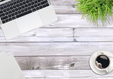 Dizüstü bilgisayar, yeşil bitkiler, ofis ahşap masanın üstüne kahve