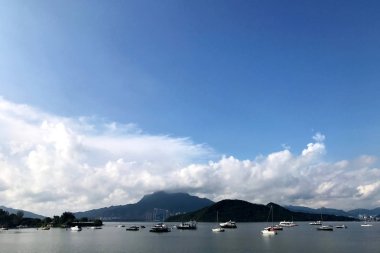 Yatay dağ, mavi gökyüzü, yelkenli ve cennet göl kenarında