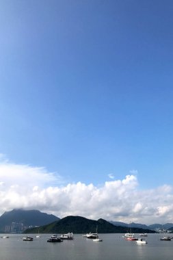 Dikey dağ, mavi gökyüzü, yelkenli ve cennet göl kenarında