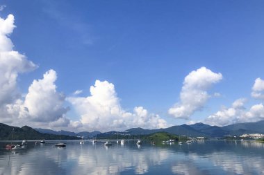 Dağ, mavi gökyüzü, yelkenli ve cennet l yansıması ile