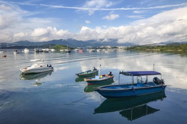 Dağ, mavi gökyüzü, tekne, yat ve yelkenli göl kenarında