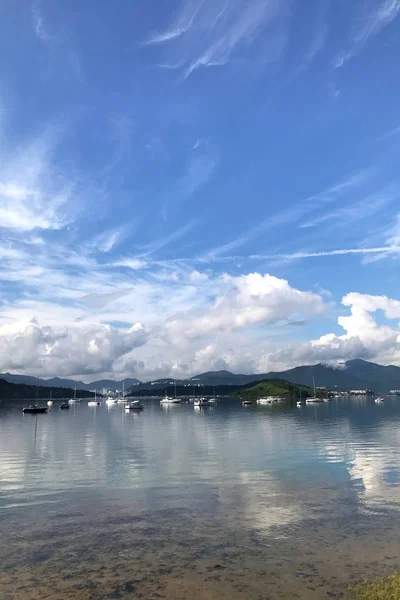 Вертикальные горы, голубое небо, лодки, яхты и парусники на озере — стоковое фото