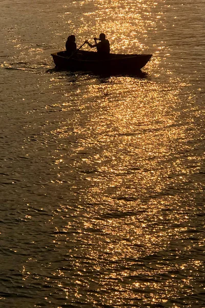 Silueta de pareja de citas, barco recreativo en el lago al atardecer —  Fotos de Stock