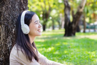 Güzel Asyalı kadın beyaz kulaklık ile müzik dinlemek
