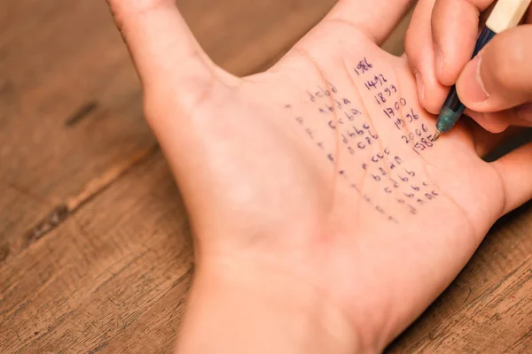 People cheating on test by writing answer on left hand