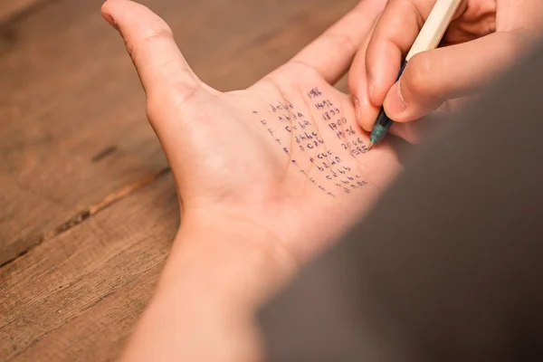 Gente haciendo trampa en la prueba escribiendo respuesta en la mano izquierda —  Fotos de Stock