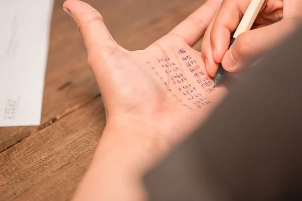 Leute betrügen Test, indem sie Antwort auf linke Hand schreiben — Stockfoto