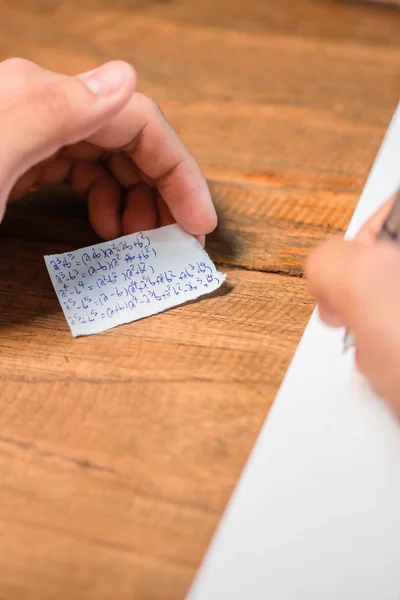 Gente haciendo trampa en la prueba por escrito respuesta en un pedazo de papel — Foto de Stock