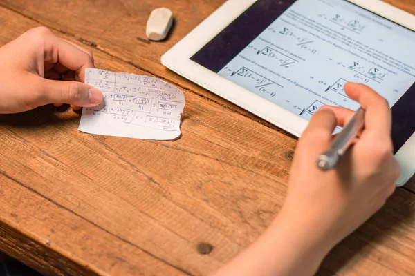 Pessoas escrevendo fomula estatística de tablet para um pedaço de papel — Fotografia de Stock