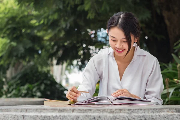 Asiatisk kvinna som arbetar utomhus i parken — Stockfoto