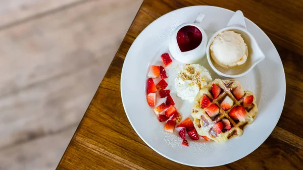 Waffle strawberry with vanilla ice cream on the table Royalty Free Stock Images