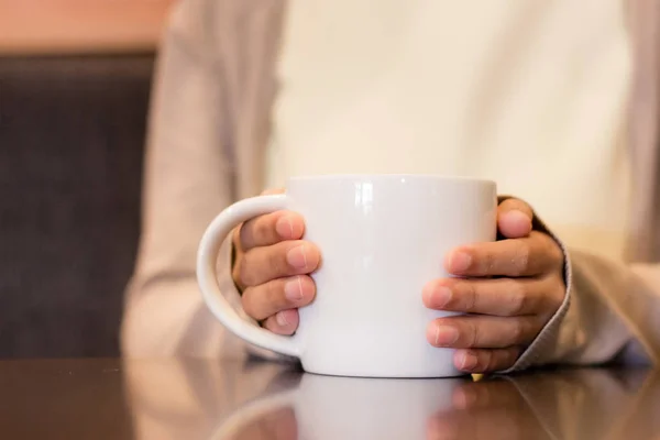 Person hand holding a white cup of coffee Royalty Free Stock Photos