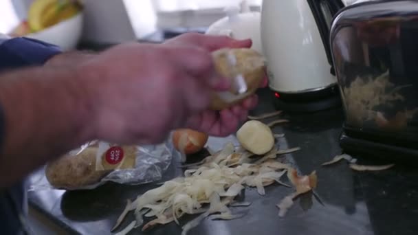 Man peeling aardappelen — Stockvideo