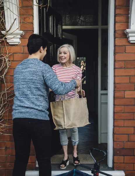 Lebensmittel an ältere Menschen liefern — Stockfoto