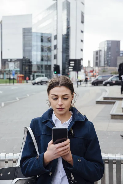 Молодая женщина со смартфоном в городе — стоковое фото