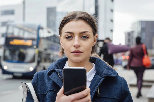 Молодая женщина со смартфоном в городе — стоковое фото