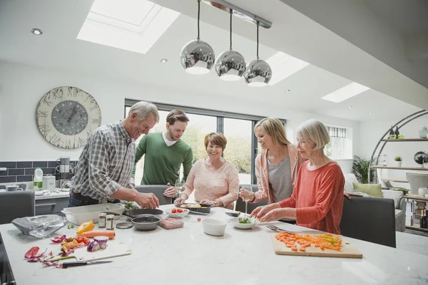 Familia cocinando juntos una comida — Foto de Stock