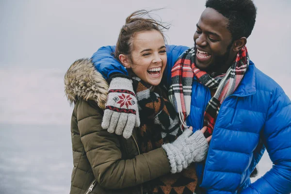 Pasangan muda tertawa di pantai musim dingin — Stok Foto