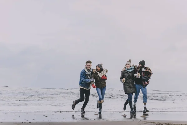 Amis s'amuser sur une plage d'hiver — Photo