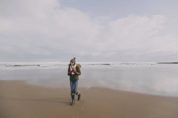 Mulher jovem andando ao longo da praia de inverno — Fotografia de Stock