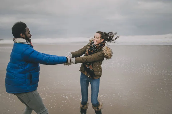 Jovem casal dança em uma praia de inverno — Fotografia de Stock