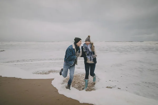 Casal jovem rindo no mar no inverno — Fotografia de Stock