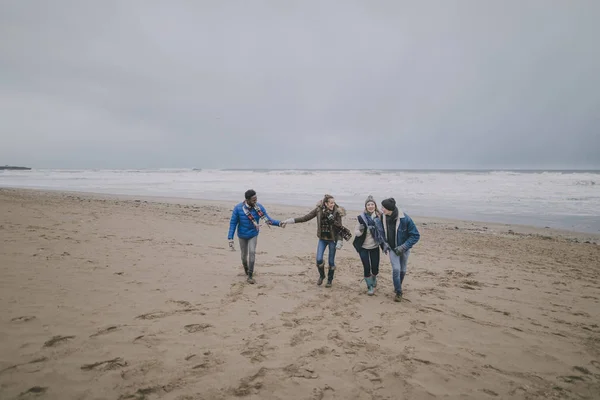 Casais caminham ao longo da praia de inverno — Fotografia de Stock