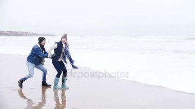 Genç bir çift deniz kışın gülüyor