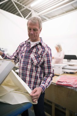 Bir kumaş depoda malzeme basarak