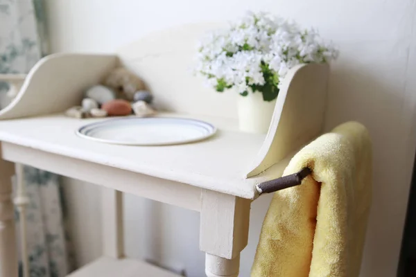 Bloemen en plaat op de kleine tafel — Stockfoto