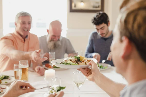 Passerar en tallrik på middagsbjudning — Stockfoto