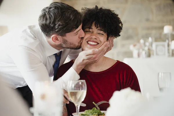 Поцелуй в щеку на свадебном ужине — стоковое фото