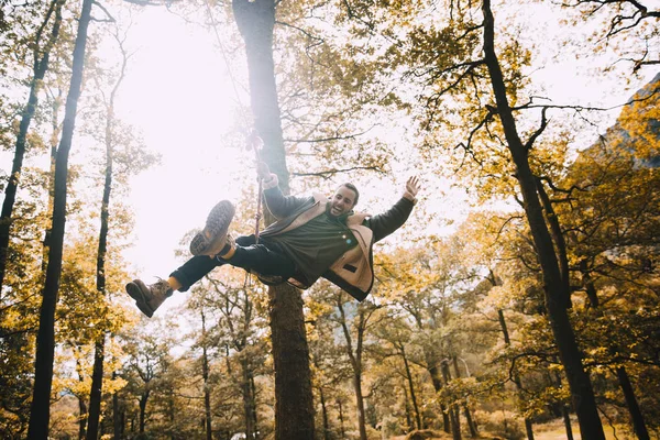 Jovem se divertindo em um balanço de corda — Fotografia de Stock