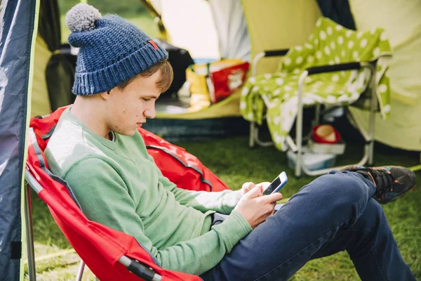 Adolescent utilisant un téléphone intelligent lors d'un voyage en camping — Photo